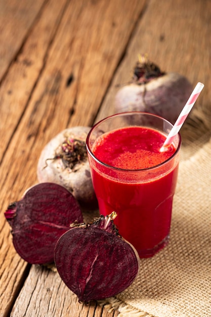 Suco de beterraba vermelha em copo de vidro sobre a mesa de madeira