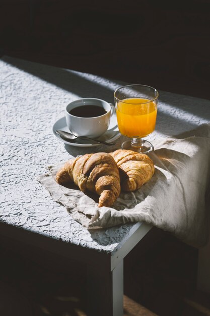 suco de café e croissants na mesa