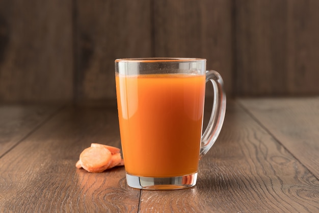 Suco de cenoura em um copo de madeira
