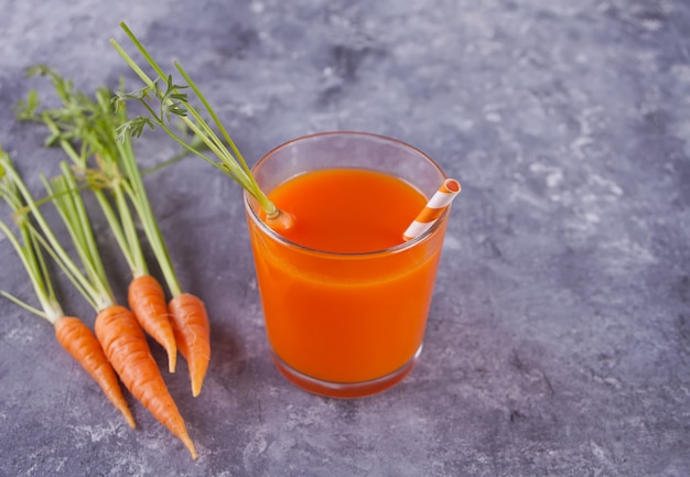 Suco de cenoura em vidro com fundo de concreto