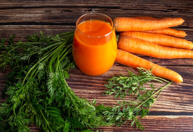 Suco de cenoura espremido em um fundo de madeira