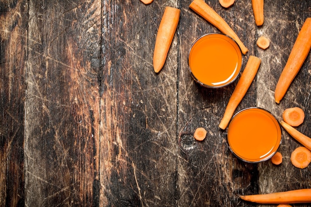 Suco de cenoura fresco na mesa de madeira