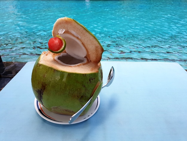 Suco de coco fresco e doce no fundo da mesa e da piscina