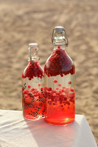 Foto suco de cranberry em uma garrafa à luz do sol sobre a mesa.