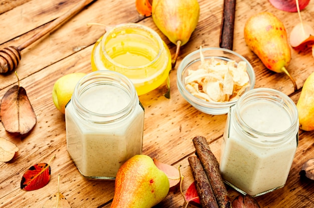 Suco de frutas de outono. Smoothie de pera e gengibre na velha mesa de madeira.