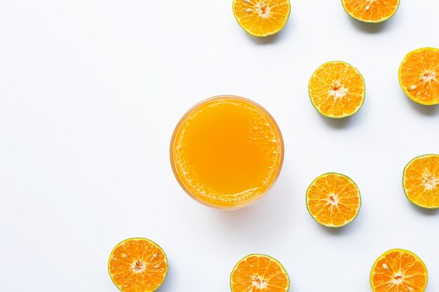 Suco de laranja com laranjas metade cortadas em branco