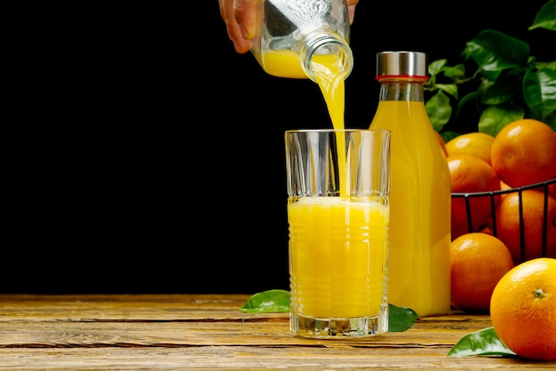 Suco de laranja derramando em vidro sobre fundo escuro suco de laranja orgânico fresco