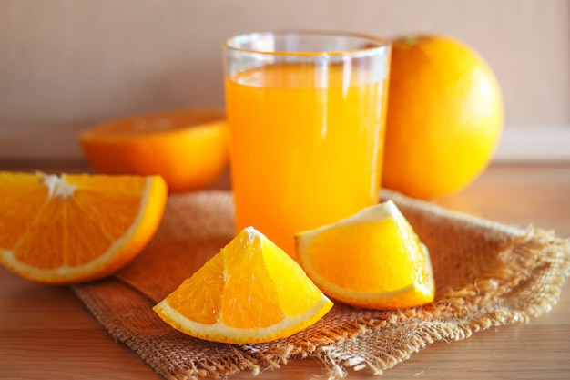 Suco de laranja e laranja em fundo de madeira