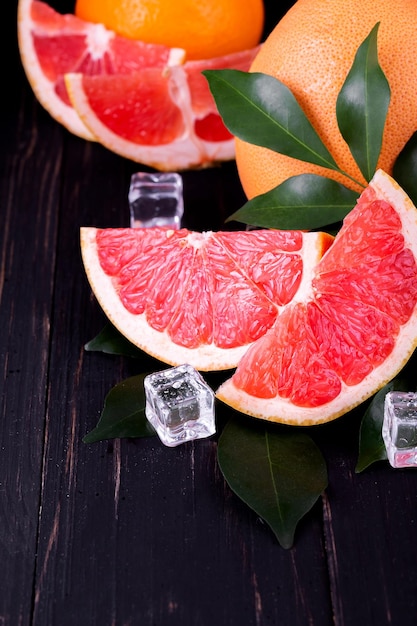 Suco de laranja e toranja em um fundo preto de madeira