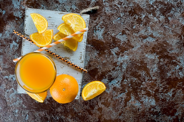 Suco de laranja em um copo e pedaços