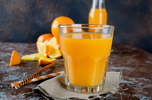 Suco de laranja em um copo e pedaços