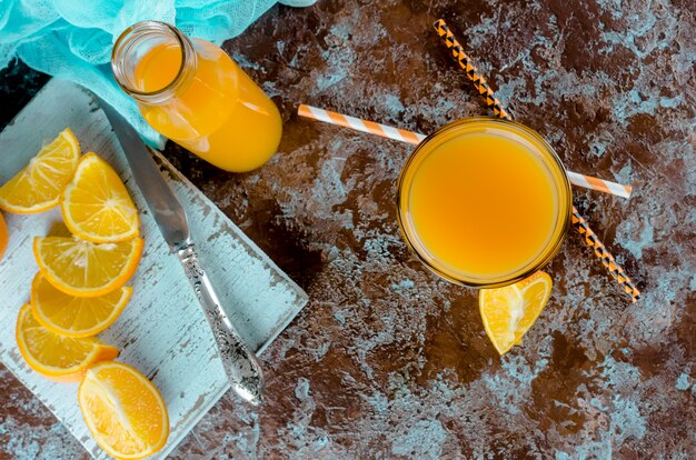 Suco de laranja em um copo e pedaços