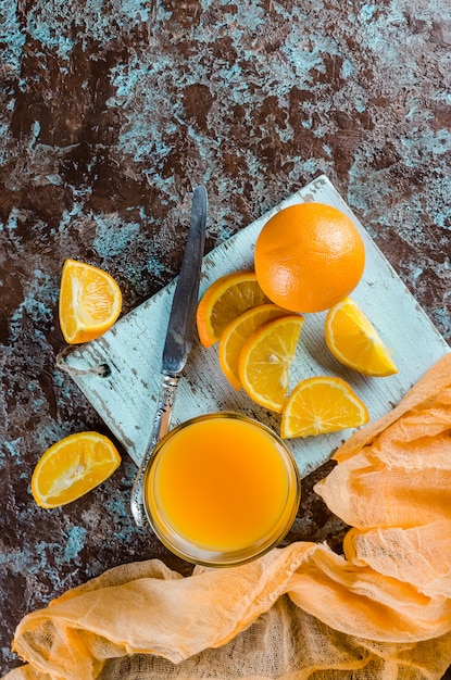 Suco de laranja em um copo e pedaços