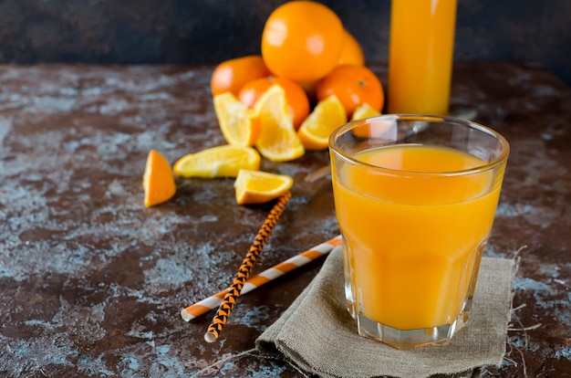 Suco de laranja em um copo e pedaços