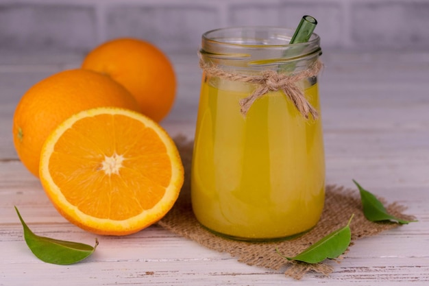 Suco de laranja em uma jarra em um fundo brancoCloseup