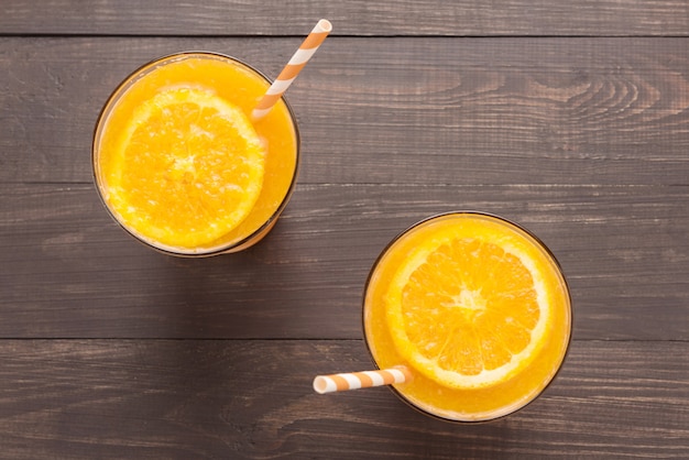 Suco de laranja em vidro com fundo de madeira