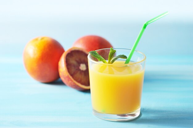 Suco de laranja em vidro com hortelã e um canudo