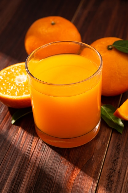 Suco de laranja em vidro e laranjas