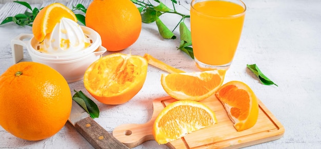 Suco de laranja espremido caseiro e frutas frescas de laranja em um fundo branco de madeira Corte a laranja.