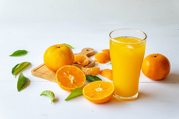 Suco de laranja espremido na hora e frutas de laranja cortadas ao meio