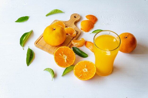 Suco de laranja espremido na hora e frutas de laranja cortadas ao meio