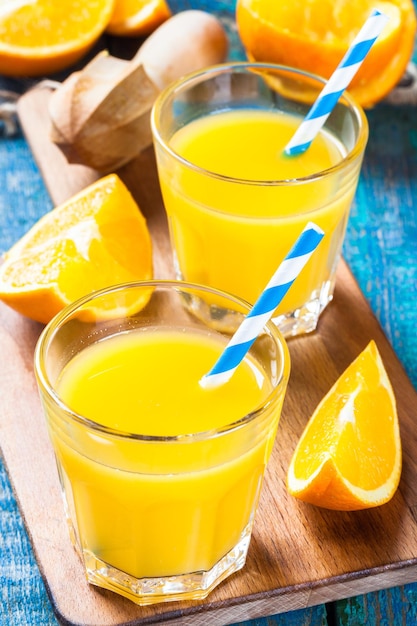 Suco de laranja espremido na hora em um copo com canudos com fatia de frutas