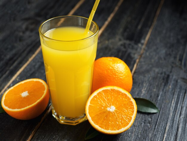 Suco de laranja fresco em fundo de madeira