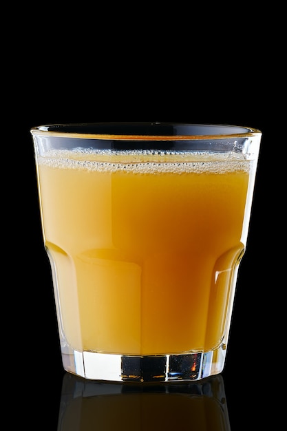Suco de laranja fresco em vidro de pedras isolado na superfície preta