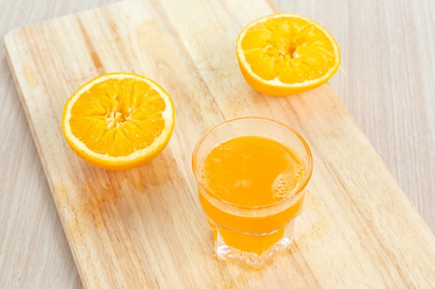 Suco de laranja fresco na tábua de madeira