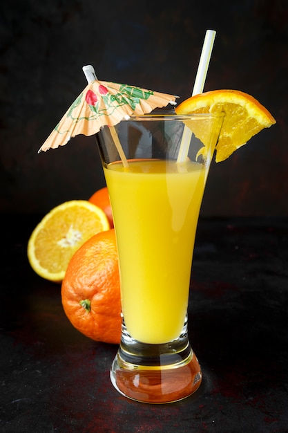 Suco de laranja natural escuro com palha e guarda-chuva