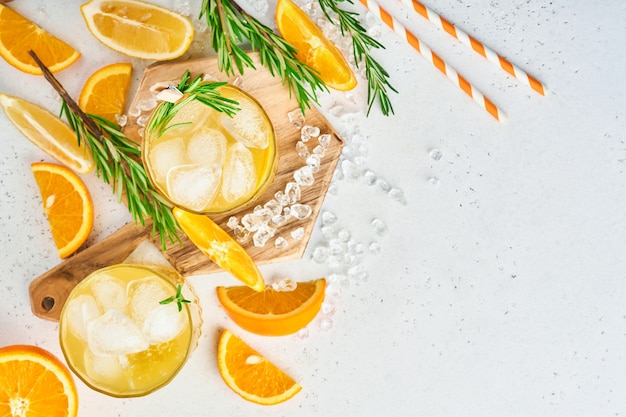 Suco de laranja ou coquetel com alecrim e laranja com gelo em copo, limonada fria de verão ou