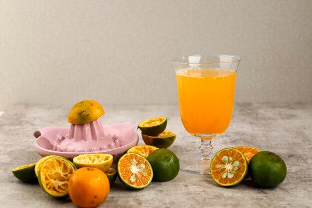 Suco de laranja recém-espremido (Jeruk Peras na Indonésia) Servir em um copo acima da mesa de cimento marrom