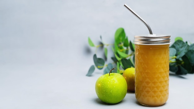 Suco de maçã fresco em vidro com canudo de metal