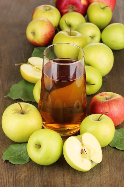 Suco de maçã útil com maçãs ao redor na mesa de madeira