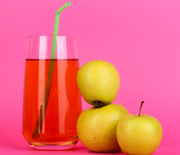 Suco de maçã útil com maçãs ao redor no fundo rosa