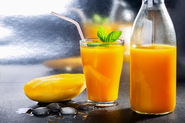 Suco de manga de smoothie de frutas tropicais frescas e manga fresca.