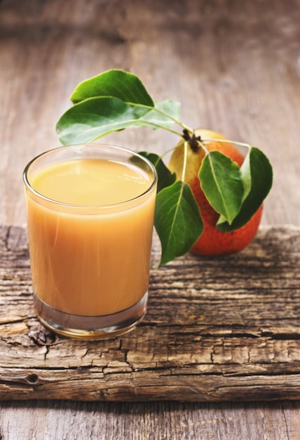 Foto suco de pêra em um copo com fundo de madeira velho