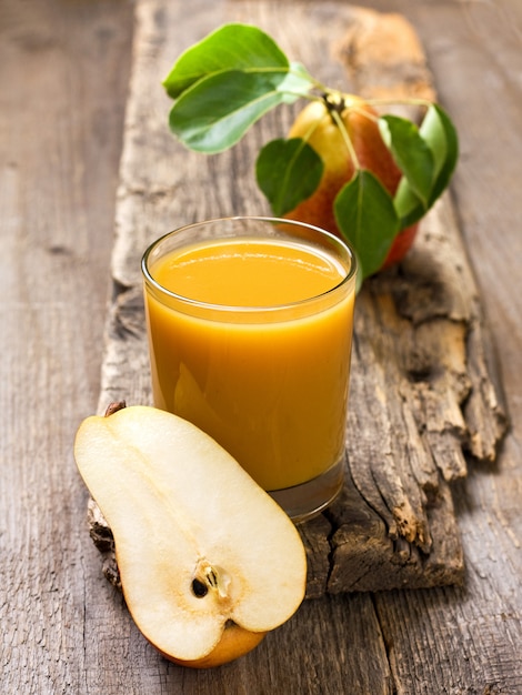 Foto suco de pêra em um copo com fundo de madeira velho