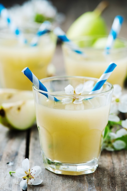 Suco de peras frescas na mesa de madeira