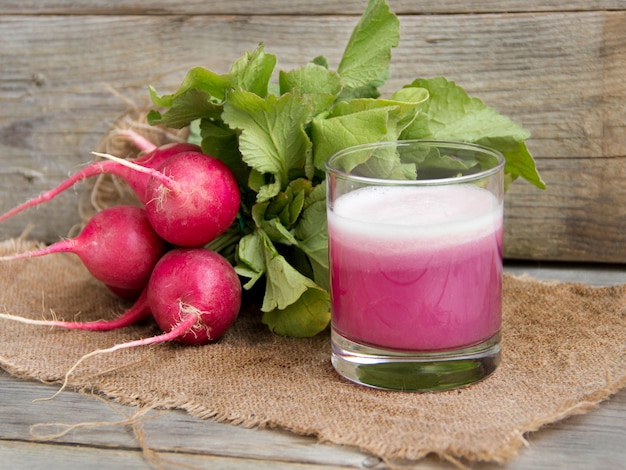 Suco de rabanete fresco em um copo sobre uma mesa de madeira fechar