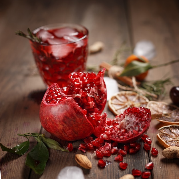 Suco de romã com romãs e frutas secas em uma mesa de madeira. Estilo sertanejo.