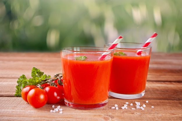 Suco de tomate com salsa e sal na mesa de madeira