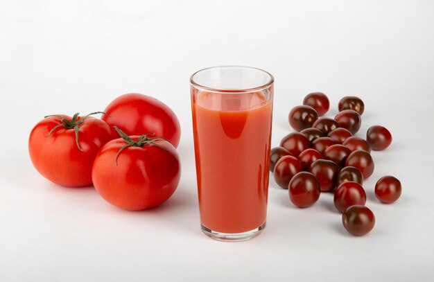 Suco de tomate e tomates frescos em um fundo branco