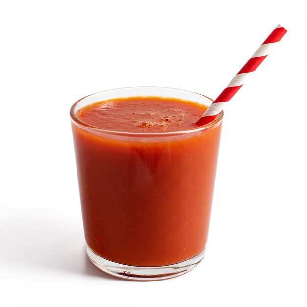 Suco de tomate em um copo isolado em um fundo branco.