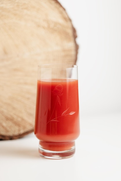 Suco de tomate em vidro transparente no espaço de cópia de fundo branco