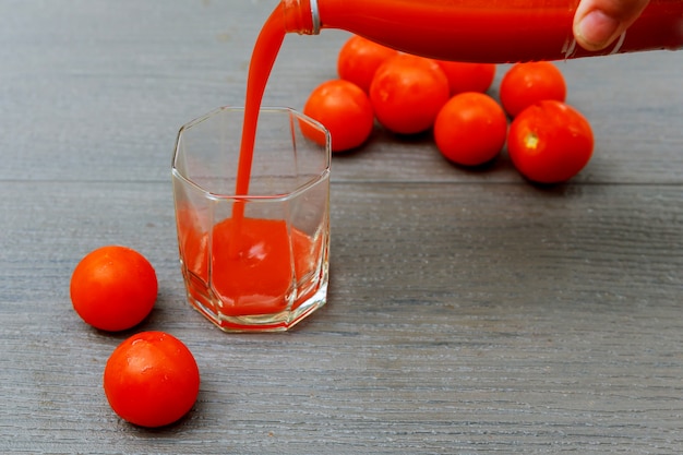 Suco de tomate recentemente feito em uma placa de madeira de jarro de vidro.