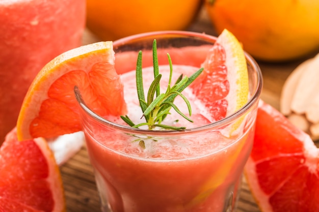 Suco de toranja com alecrim e gelo em um copo sobre a mesa.