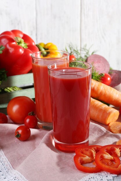 Suco de vegetais e legumes frescos em guardanapo na mesa de madeira no fundo da parede de madeira