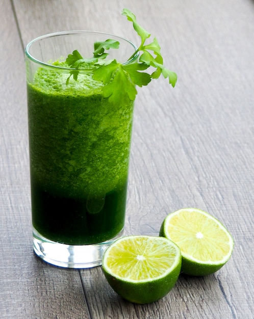 Suco de vegetal verde saudável na mesa de madeira