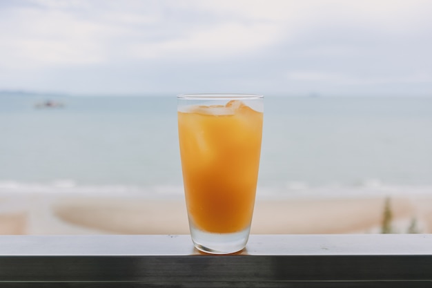 Suco em um copo com vista para o mar no conceito de verão